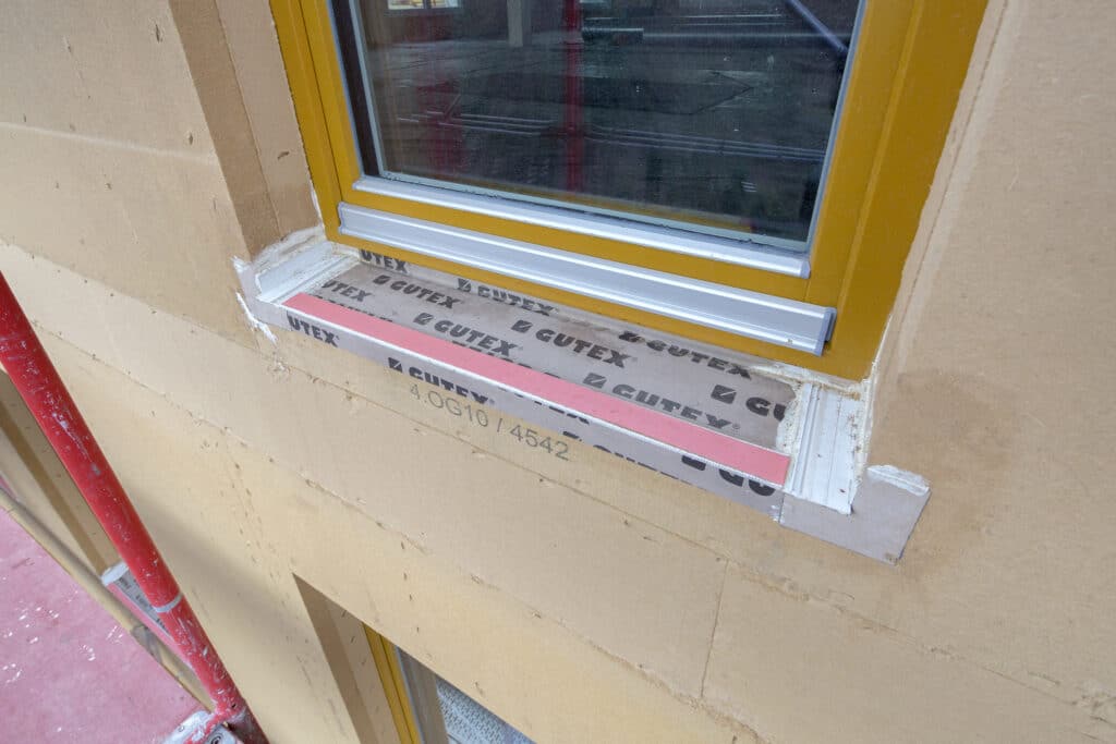 Dichte Gebäudehülle mit wind- und schlagregensicheren Fensteranschlüssen aus der Vorfertigung: Dank des geprüften Fensteranschluss-Systems Implio F von GUTEX stehen auf der Baustelle nur noch Putzarbeiten an.  